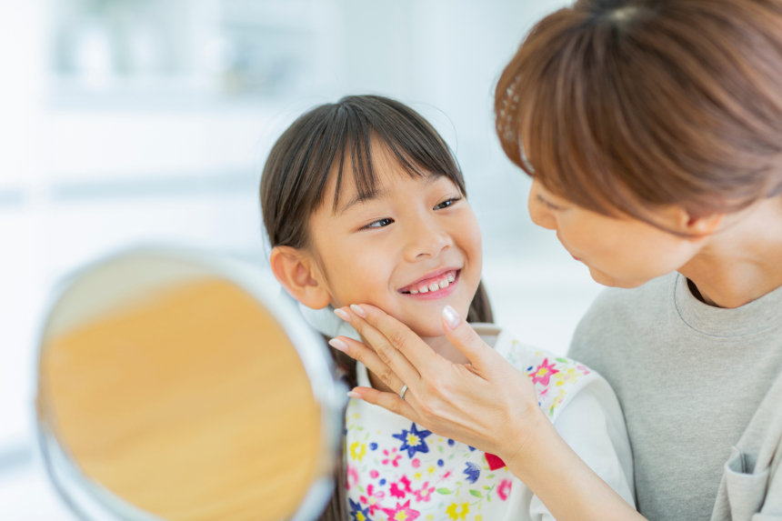 娘の歯並びを確認し微笑ましく見つめる母親