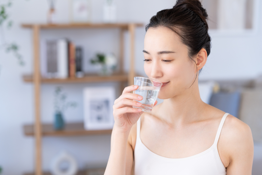マウスピースを装着した状態で水を飲む女性
