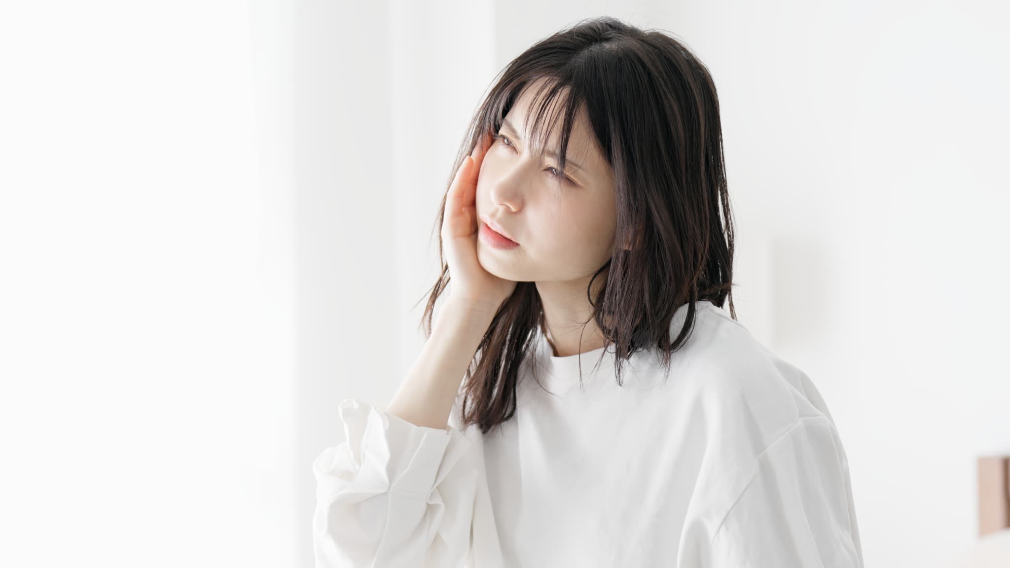 ワイヤー矯正中に痛みを感じる女性