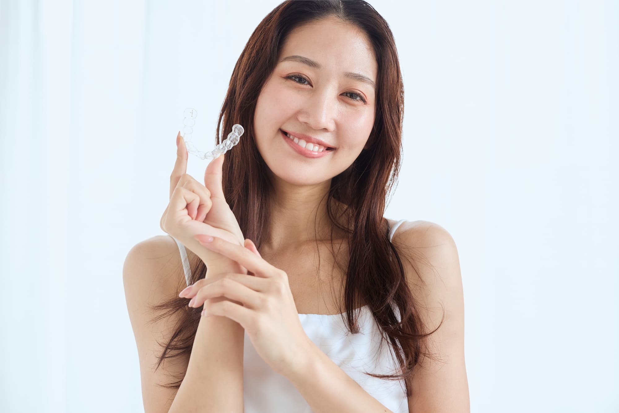 虫歯を治療してマウスピース矯正を続ける女性