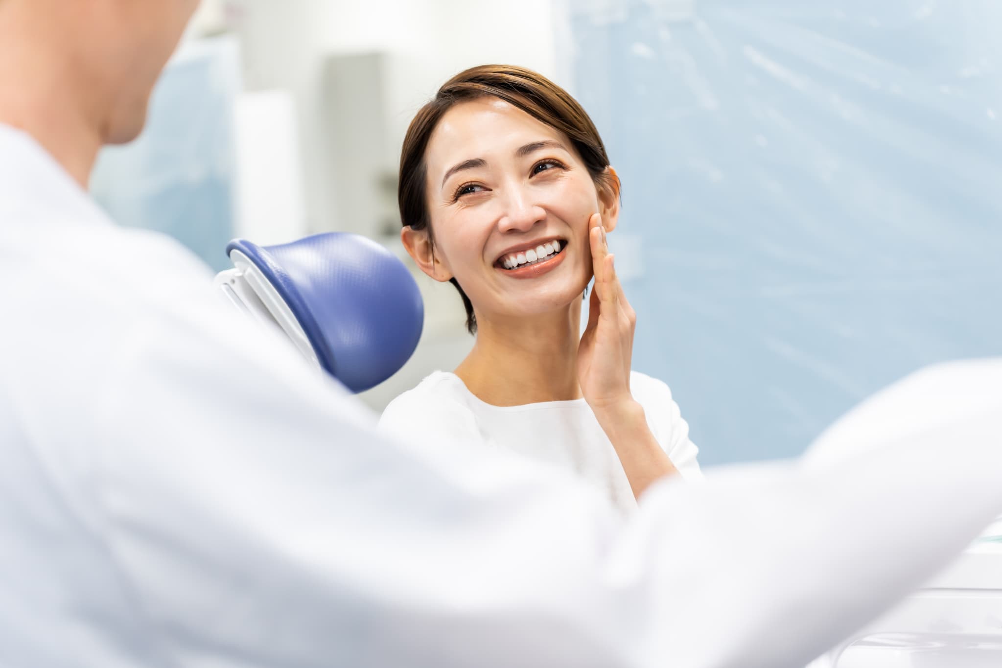 歯科医院で知覚過敏の治療をしてもらって笑顔の女性