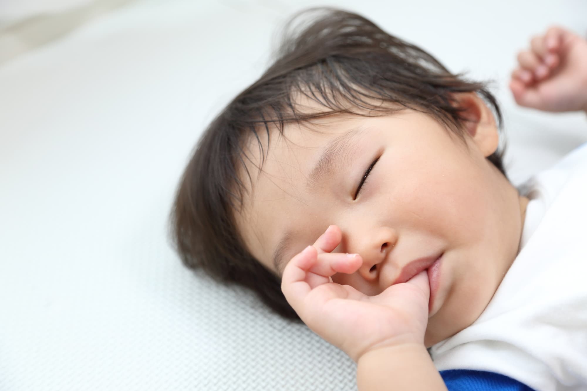 指しゃぶりをしながら眠る男の子