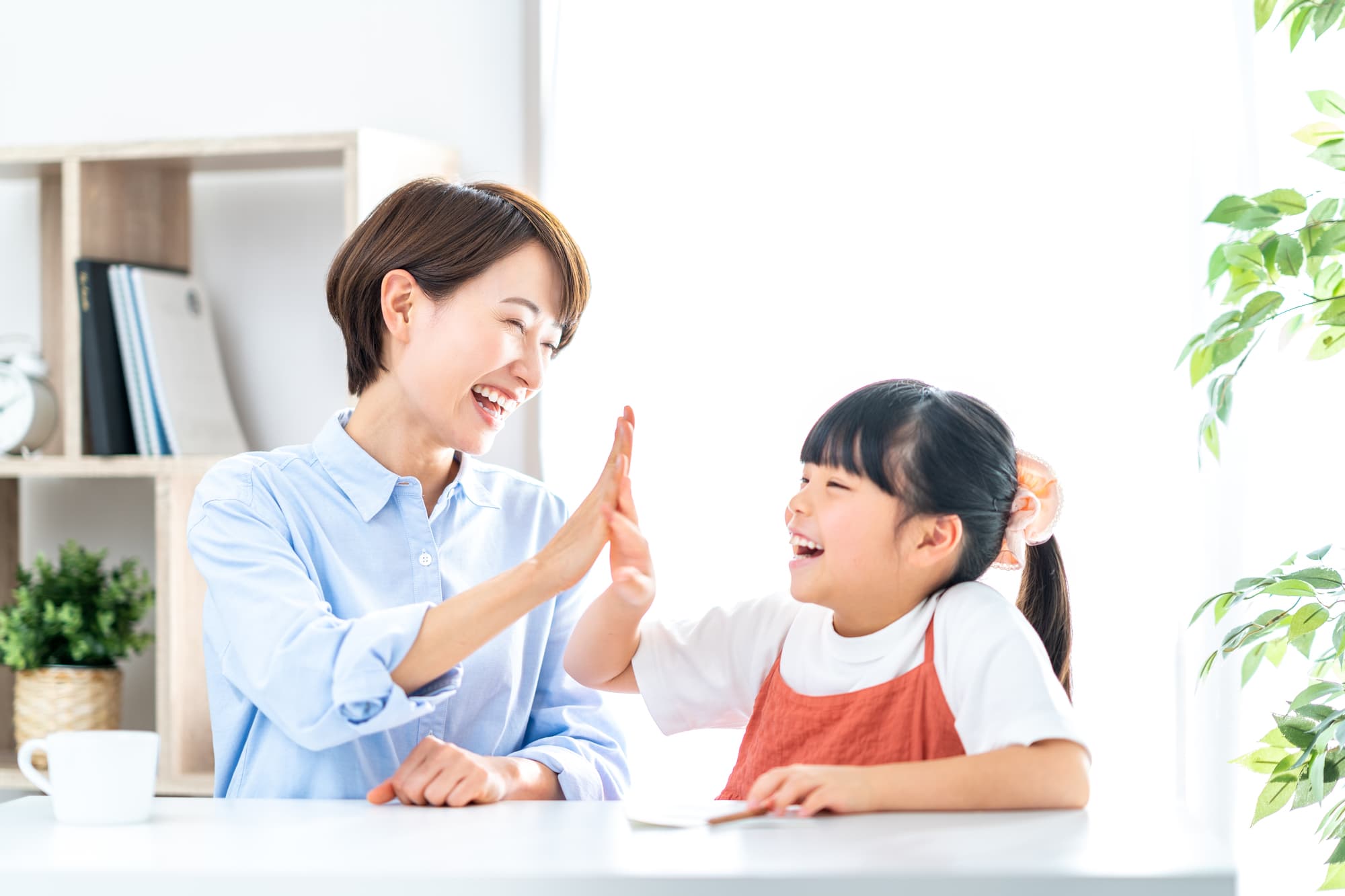 出っ歯を矯正して母親とハイタッチをして喜ぶ女の子