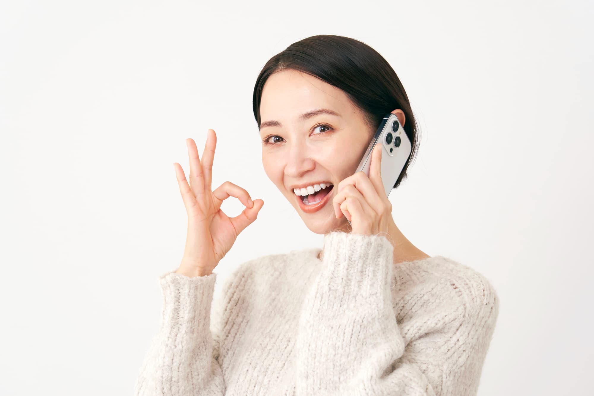 滑舌が気にならなくなりOKサインをしながら電話する女性