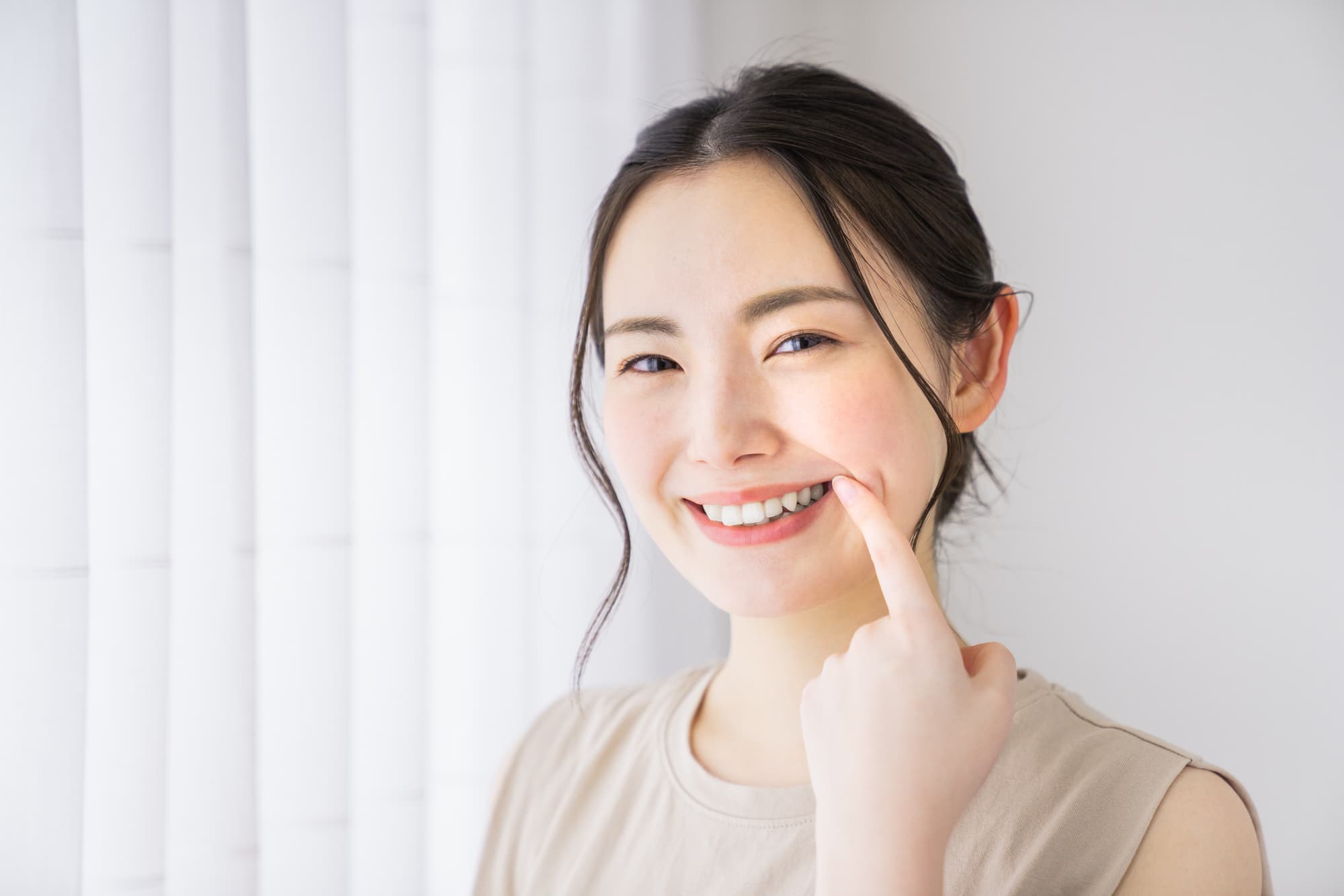 白い歯を見せて笑う女性