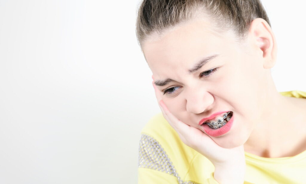 ワイヤー 矯正中にできた口内炎が痛む女性