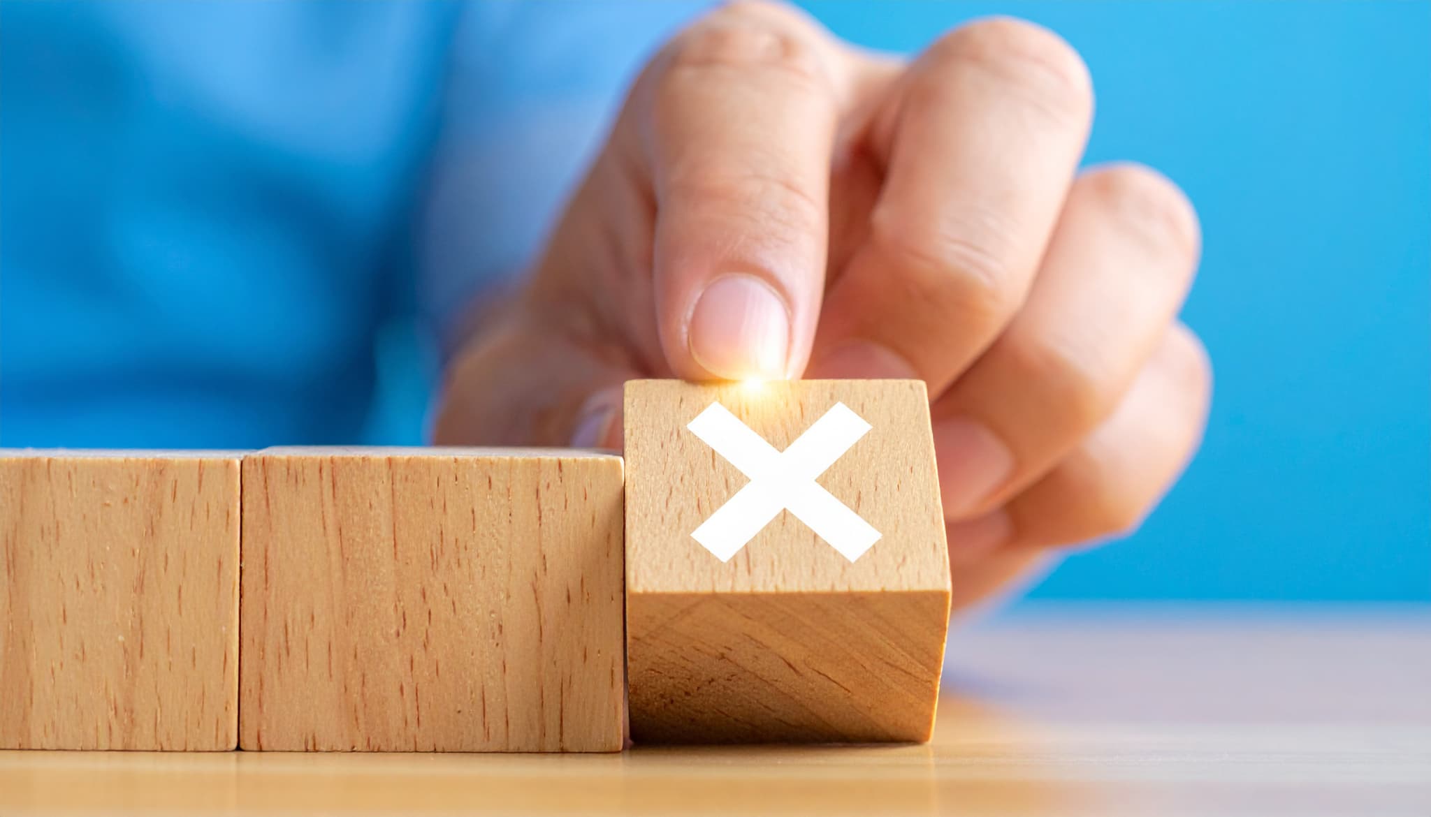 歯の黄ばみを落とすのにやってはいけないことを示すバツの積み木を選択する指