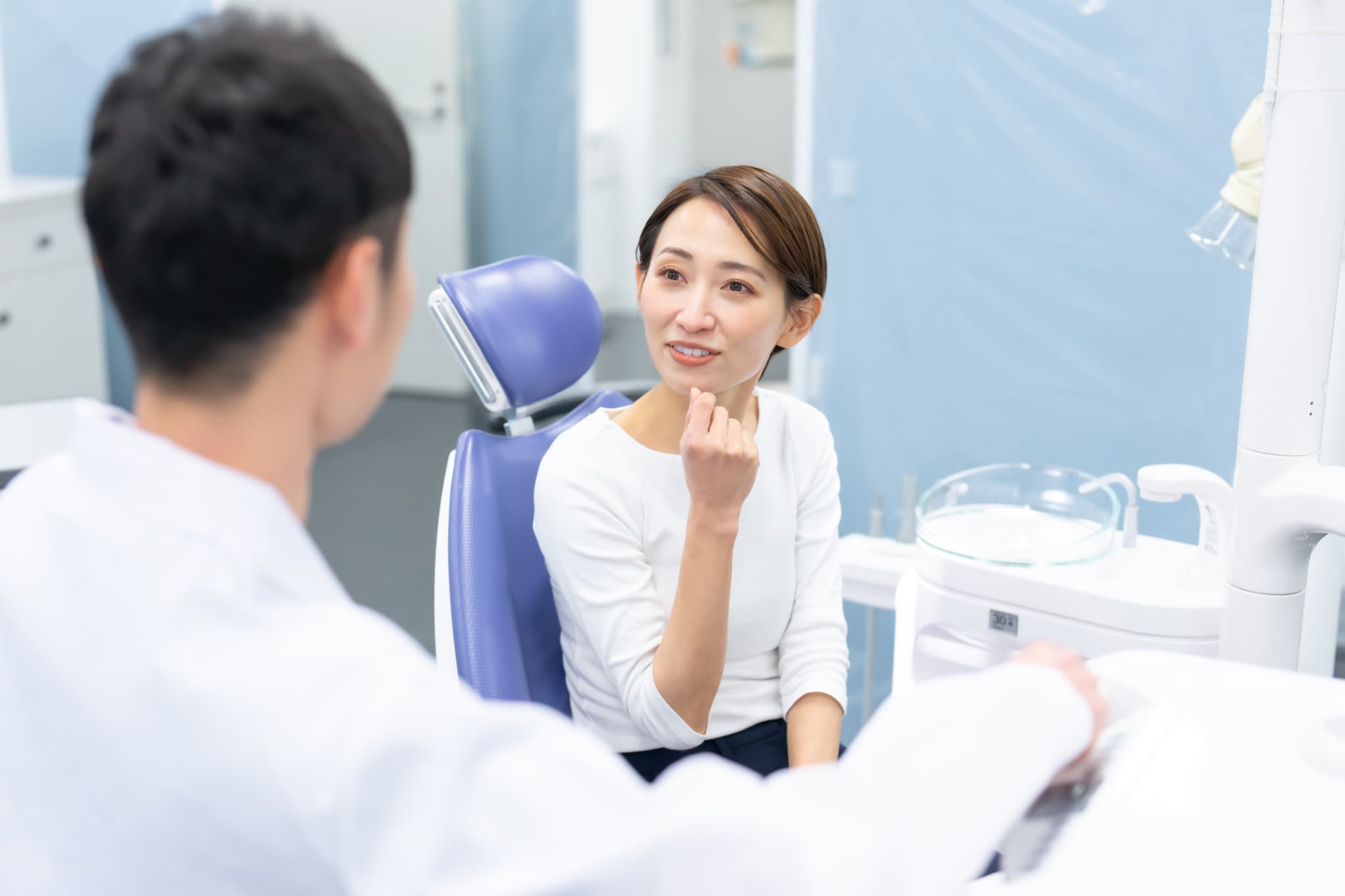 歯科医院で後戻りの相談をする女性