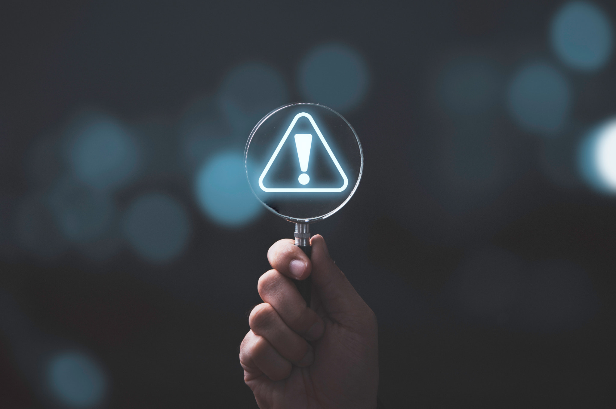 ホームホワイトニングを行うときの注意点を示す手に持った虫眼鏡の中に浮かぶビックリマーク